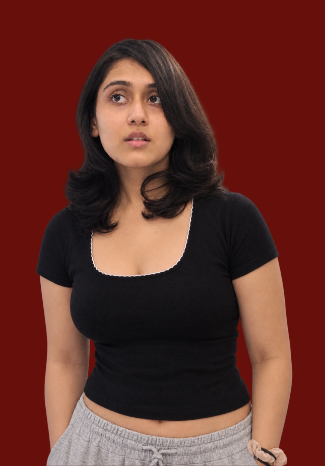 Digital marketing freelancer Harshita Chauhan pictured in a black scoop-neck top against a plain maroon backdrop.